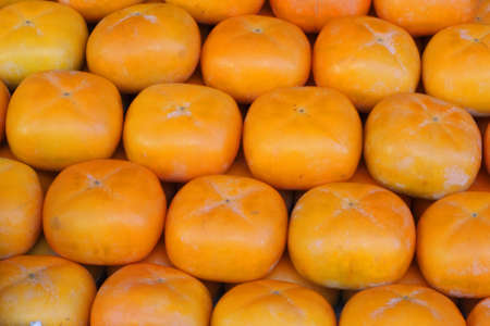 Persimmons fruits on a fruits market stallの写真素材