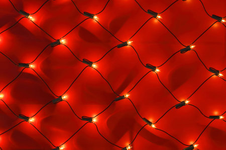Detail of a red wall with Christmas lights net.の写真素材