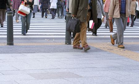 People crossing the street in a big city-very low perspective and soft focus.の写真素材