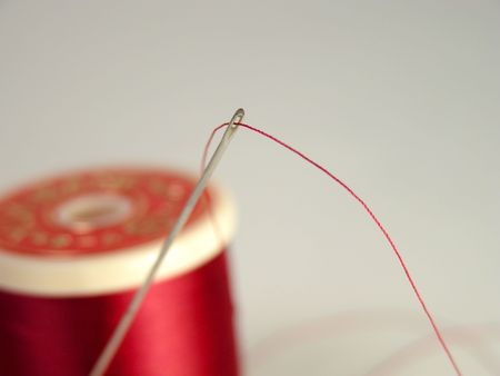 Needle and spool of thread.Focus on the needle rest of the image is blurry.の写真素材