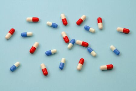 Two types of antibiotics:amoxicillin and oxacillin, over blue background.の写真素材