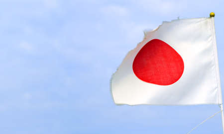 Image of a old Japanese ship flag over a cloudy sky.の写真素材