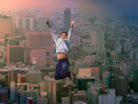 Young businesswoman doing early morning exercise on a skyscraper  roof in a big city.          の写真素材