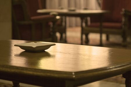 Abstract image of a hotel hall with an ashtray on a table and interesting lighting.の写真素材