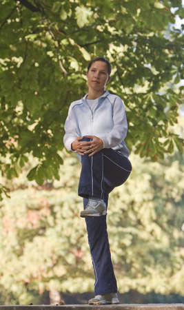 Woman doing warming up movements outdoors in a park.
の写真素材
