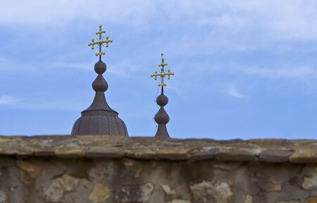 The spires of a Romanian monastery (Varatec-Moldavia) showing above the surrounding wall.の写真素材