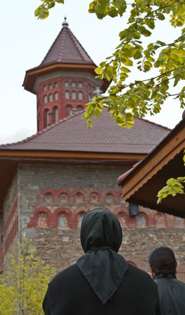 Image of a nun praying in front of a Romanian Monastery.の写真素材