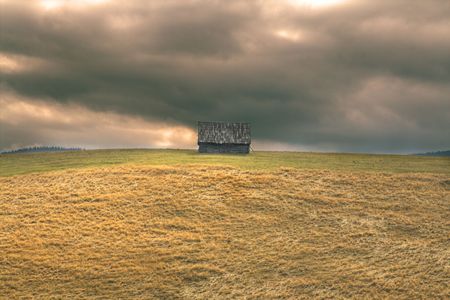 Lonely hut in a mountain area with a dramatic heavy sky.Location: Paltinis,Romania.