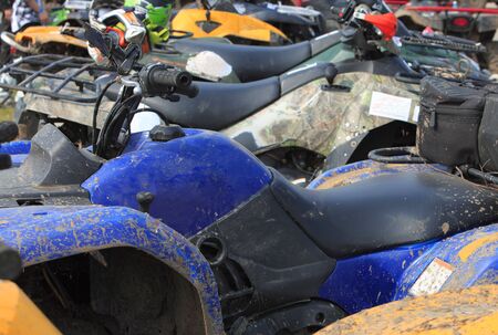 Selective focus on the ATV brake in a crowd of bikes during a muddy race pause. の写真素材