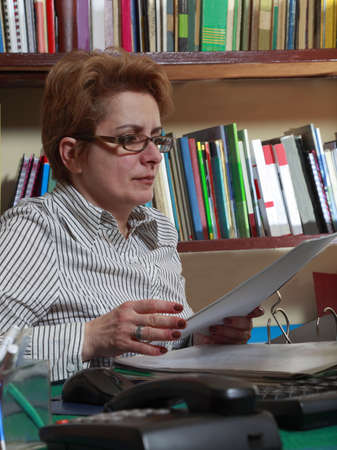 Woman with a folder at her home business desk.の写真素材