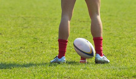 A rugby player's legs preparing to kick a rugby ball.の写真素材