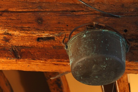Old rusty copper pot hanging in a girderの写真素材