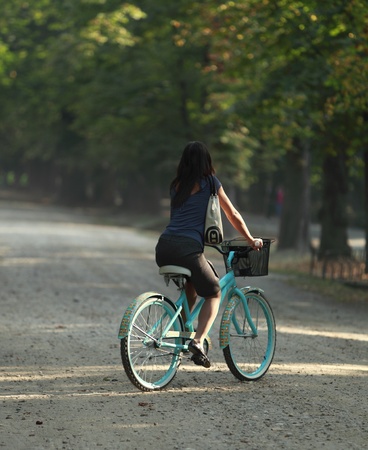 Young woman riding a bicycle in a park in the morning.の写真素材