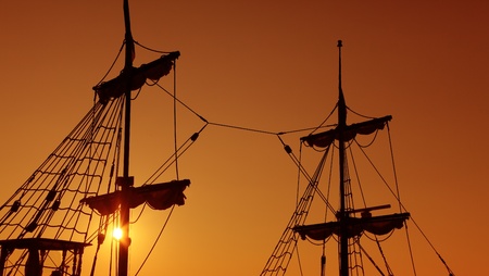 Silhouettes of old-fashioned masts against a twilight sky suggesting idea of navigationの写真素材