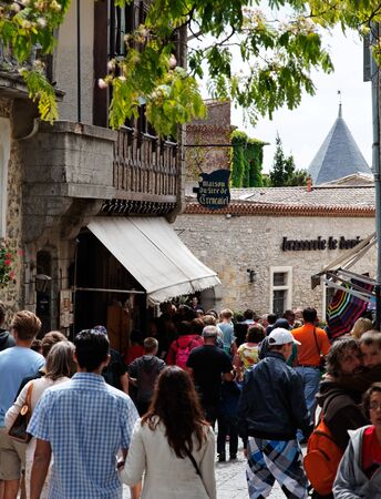 Carcassonne,France,July 17th 2011:  Image of crowd of tourists in a commercial street in the fortified city of Carcassonne in Aude department of France.The historic city of Carcassonne is an excellent example of a medieval fortified town whose massive defのeditorial素材