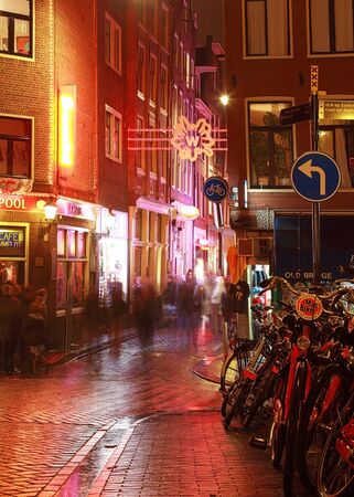 Amsterdam,Netherlands- October 30th, 2011: Verical image during the night of a wet cobbled street nicely illuminated in Amsterdam.のeditorial素材