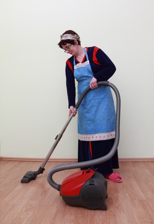 Housewife using a vacuum cleaner to clean the floor.の写真素材