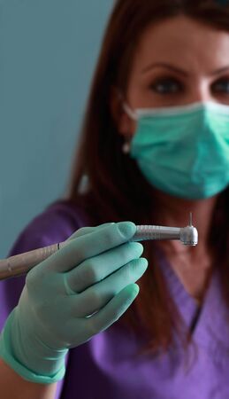 Image of a dentist woman holding a drill. Selective focus on the drill.の写真素材