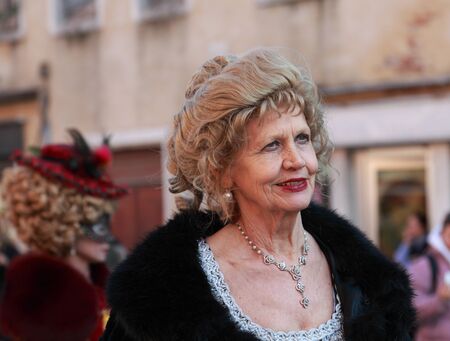 Venice,Italy- February 26th, 2011: Enviromental portrait of a beautiful old lady participating in a costumes parade on Sestiere Castello during the Venice Carnival days.The Carnival of Venice (Carnevale di Venezia) is an annual festival, held in Venice, Iのeditorial素材