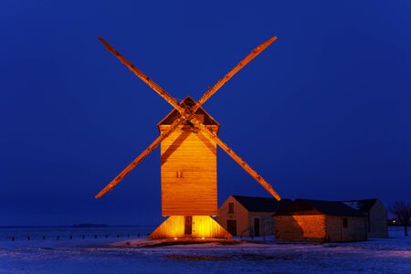 Night image of an old traditional wooden windmill in a field covered by snow.This windmill is The big windmill from Ouarville from Eure&Loir regon of France.の写真素材