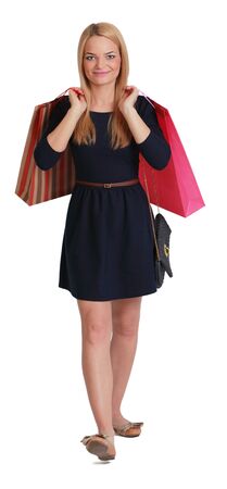Young blonde woman with two shopping bags walking to the camera against a white background.の写真素材
