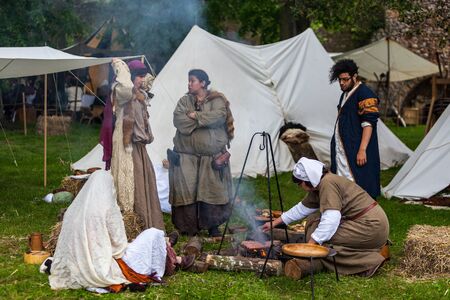 Nogent le Rotrou, France- May 19, 2012: A group of medieval people cooking outdoor near their traditional tents, during a historical reenactment festival in Nogent le Rotrou, France.のeditorial素材