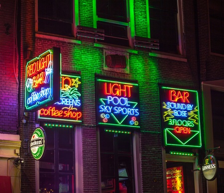 Amsterdam,Netherlands- October 31st 2011: Night image of colorful coffee shop signs in the red district from Amsterdam.のeditorial素材