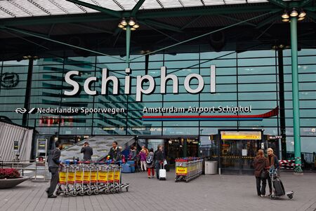 Amsterdam,Netherlands- October 31st 2011: People doing various activities in front of the main entrance in Schiphol airport in Amsterdam.のeditorial素材