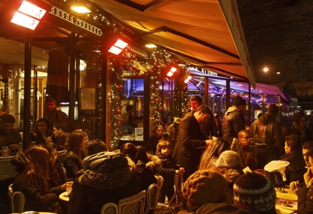 Paris,France- December 31, 2012: Crowded Parisian street terrace full of people having a frugal New Year's Eve night snack few hours before the end of the year 2012.Due to very bad weather condition (heavy rain) there was not the usual fireworks show in Pのeditorial素材