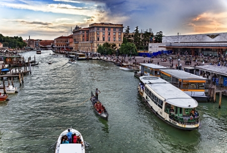 Venice, Italy- July 28,2011:  Image of a traditional gondolier and a waterbus on the Grand Canal in Venice near the Venetian railway station and Ferrovia Vaporetto station.のeditorial素材