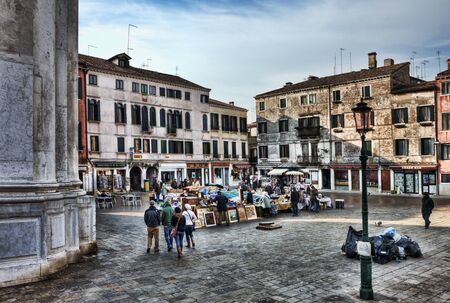 Venice,Italy- February 18, 2012:People walking and opening the market stands in a Venetian market square in the morning, during the Venice Carnival days.のeditorial素材