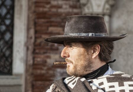 Venice, Italy-February 18, 2012:Environmental portrait of a person with a six-shooter disguised as an old time western mercenary posing for tourists in Venice during The Carnival days.のeditorial素材