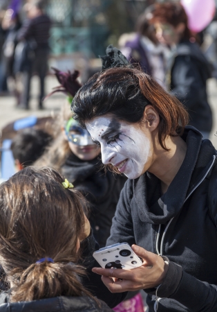 Venice,Italy-February 26, 2011: Environmental portrait of a female street face painter working on Sestiere Castello in Venice during the Venice carnival days.のeditorial素材