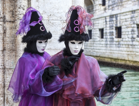 Venice, Italy- February 198th, 2012:Portrait of a couple disguised in Venetian costumes posing near a channel during the Venice Carnival days.のeditorial素材