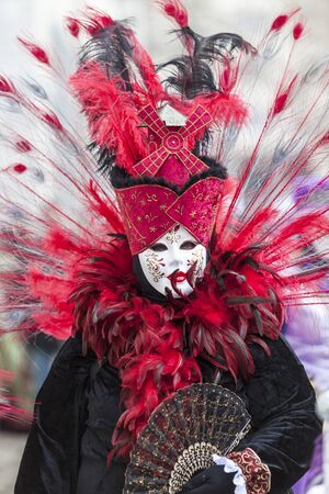 Annecy, France- February 23, 2013: Environmental portrait of an unidentified person disguised in a beautiful costume in Annecy, France, during a Venetian Carnival, which is held yearly, to celebrate the beauty of the real Venice.のeditorial素材