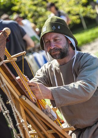 Arville,France- May 23,2010: Environemntal portrait of a medieval leatherworker doing his job during a historical reenactment festival in Arvile, Franceのeditorial素材