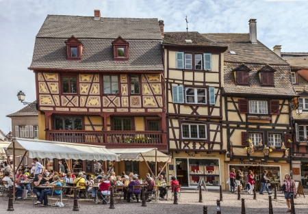 Colmar,France- April 23rd, 2011: People relaxing on street terraces in a town square near traditional half-timbered houses in Colmar, Alsace, France.のeditorial素材