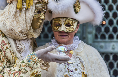 Venice, Italy- February 19th, 2012  Environmental portrait of a disguised couple looking to a magic ball in San Marco Square during The Carnival days  Slective focus on the ball のeditorial素材