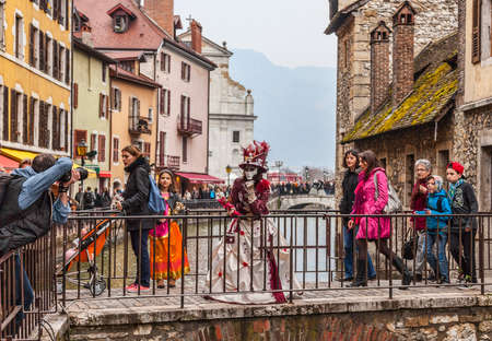 Annecy,France-March 15,2014 Unidentified photographer shooting a disguised person located on a small bridge over a canal during the Annecy Venetian Carnival  Yearly in Annecy ,France is held a Venetian Carnival to celebrate the beauty of the real Venice のeditorial素材