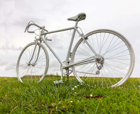White vintage bicycle in a green field.の写真素材