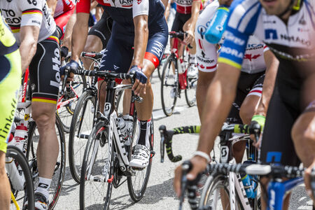 Col du Lautaret, France - July 19, 2014: Image of the legs of cyclists inside the peloton, pedalling during the stage 14 of Le Tour de France 2014 on Col du Lautaret in Hautes Alpes.のeditorial素材