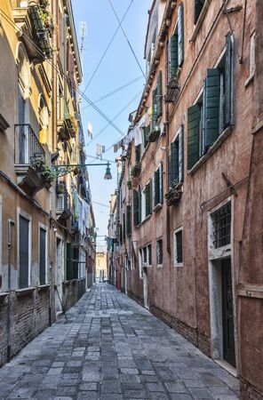 Narrow street between old buildings in Venice. This is a ty;pical street called "Ramo" which is a narrow street branched out of a bigger one and having a dead end, a canal.の写真素材