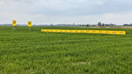 Camphin-en-Pevele,France-April 13,2014:Yellows Banners of the LCL Bank on the roadside of a cobblestone road in Camphin-en-Pevele town during the 2014 edition of Paris-Roubaix cycling race.のeditorial素材