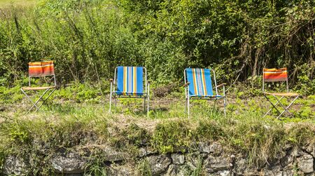 Row of colorful empty chairs of the spectators of Le Tour de France located on the side of the road to Col de Tourmalet during stage 18 of le Tour de France 2014.の写真素材