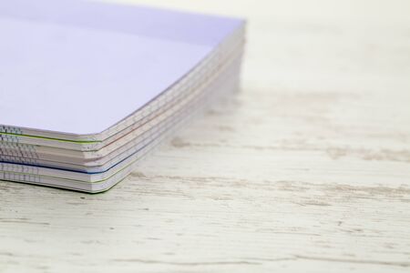 Image of a stack of colorful notebooks on a white wooden table.の写真素材