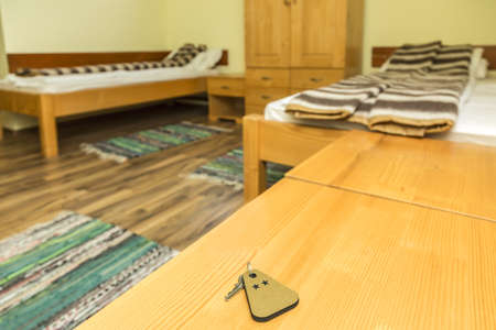 A key of a two stars hotel room is on a wooden table. Selective focus.の写真素材