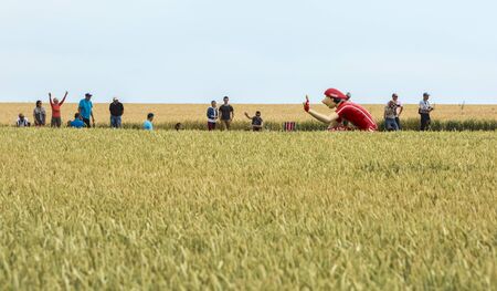 Quievy,France - July 07, 2015: Vittel mascot in a wheat field, during the passing of the Publicity Caravan on a cobblestone road in the stage 4 of Le Tour de France on July 7 2015 in Quievy, France.のeditorial素材
