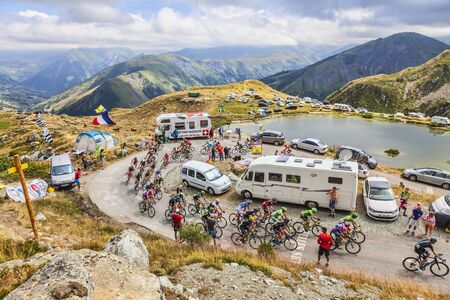 Col de la Croix de Fer, France - 23 July 2015: The peloton riding in a rocky natural environment near the Laitelet Lake, at Col de la Croix de Fer in Alps during the stage 20 of Le Tour de France 2015.のeditorial素材
