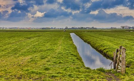 Rural Dutch landscape (polder) with a specific canal in a green field.の写真素材