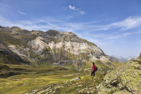 Female hiker admiring the landscape from the center of the glacial Circus of Troumouse, one of the largest from the Europe.の写真素材